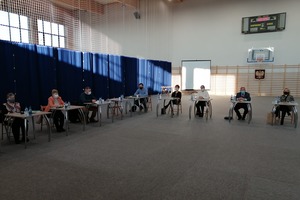 Sesja Rady Gminy , która odbyła się na Hali Widowiskowo-Sportowej w Miejskiej Górce. Na zdjęciu znajduje się kilku radnych siedzących w ławkach. (photo)