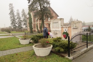 Zdjęcie przedstawia burmistrza składającego kwiaty przed pomnikiem. (photo)