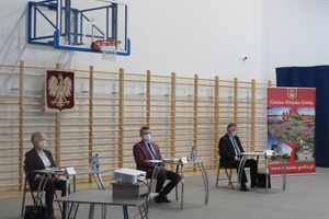 Zdjęcie z sesji rady Miejska Górka. Na fotografii znajduje się trzech radnych oraz plakat gminy Miejska Górka. (photo)