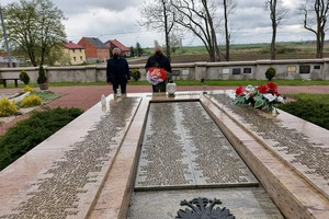 Burmistrz oraz jego zastępca składają wiązankę biało - czerwonych kwiatów na pomniku ofiar II wojny światowej. (photo)