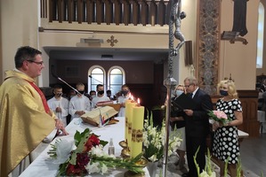 Na zdjęciu znajduje się ksiądz stający za ołtarzem, a w tle znajdują się ministranci. (photo)