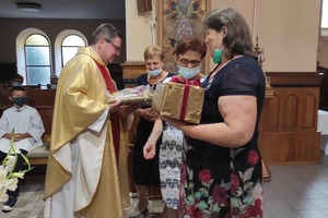 Na zdjęciu znajduje się ksiądz odbierający prezenty od parafian. (photo)