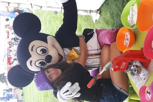 Na zdjęciu znajduję się dziewczyna przytulająca maskotkę myszki Miki. (photo)