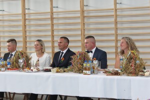 Siedzący za stołem mężczyźni i kobiety odbierający wieńce (photo)