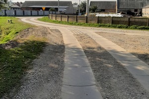 Na pierwszym planie droga śladowa w Oczkowicach, w tle zabudowania (photo)