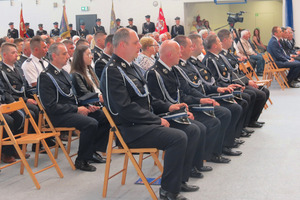 Strażacy w mundurach siedzący na krzesłach w trakcie wydarzenia (photo)