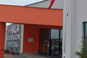 Na pierwszym planie maszt z flagą, na drugim planie hala Widowiskowo-Sportowa w Miejskiej Górce (photo)