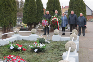 Delegacja składa kwiaty przed zbiorową mogiłą Powstańców Wielkopolskich na cmentarzu parafialnym. Burmistrz ora Marszałek trzymają w rękach biało-czerwone wieńce (photo)