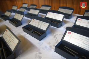 Na stole znajduje się kilkanaście upominków - etui wraz z długopisami (photo)